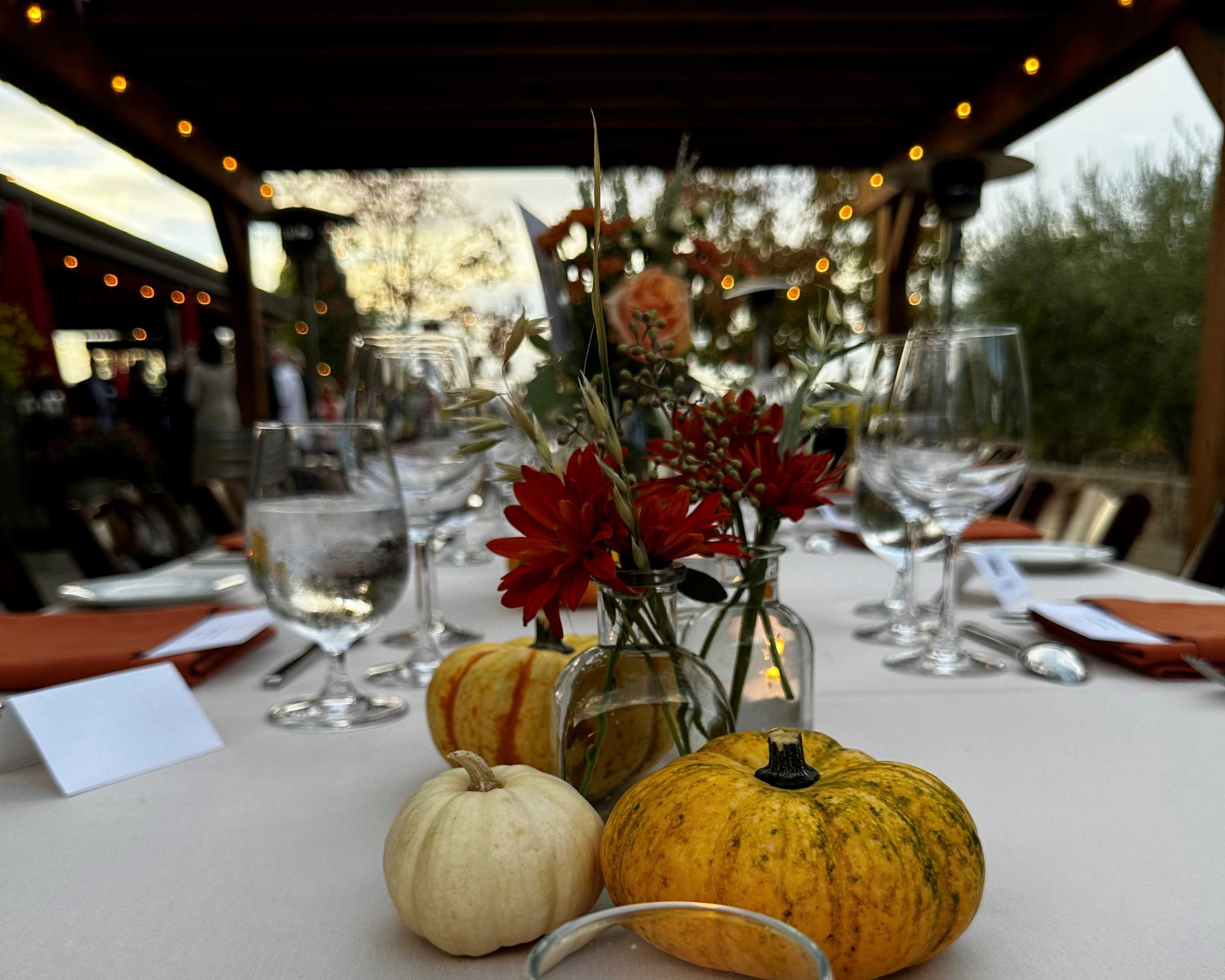 Harvest decor and wine glasses on a long table at the Biale Back Porch